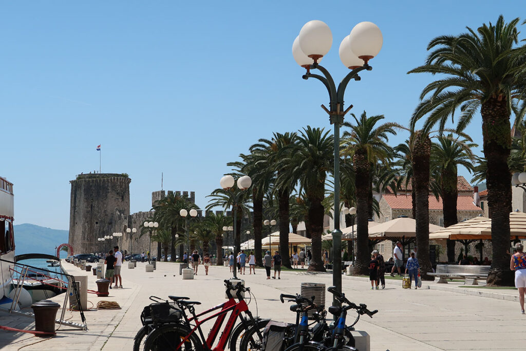 Blick auf Altstadt in Trogir mit Burg, Palmen und Straßenlaternen