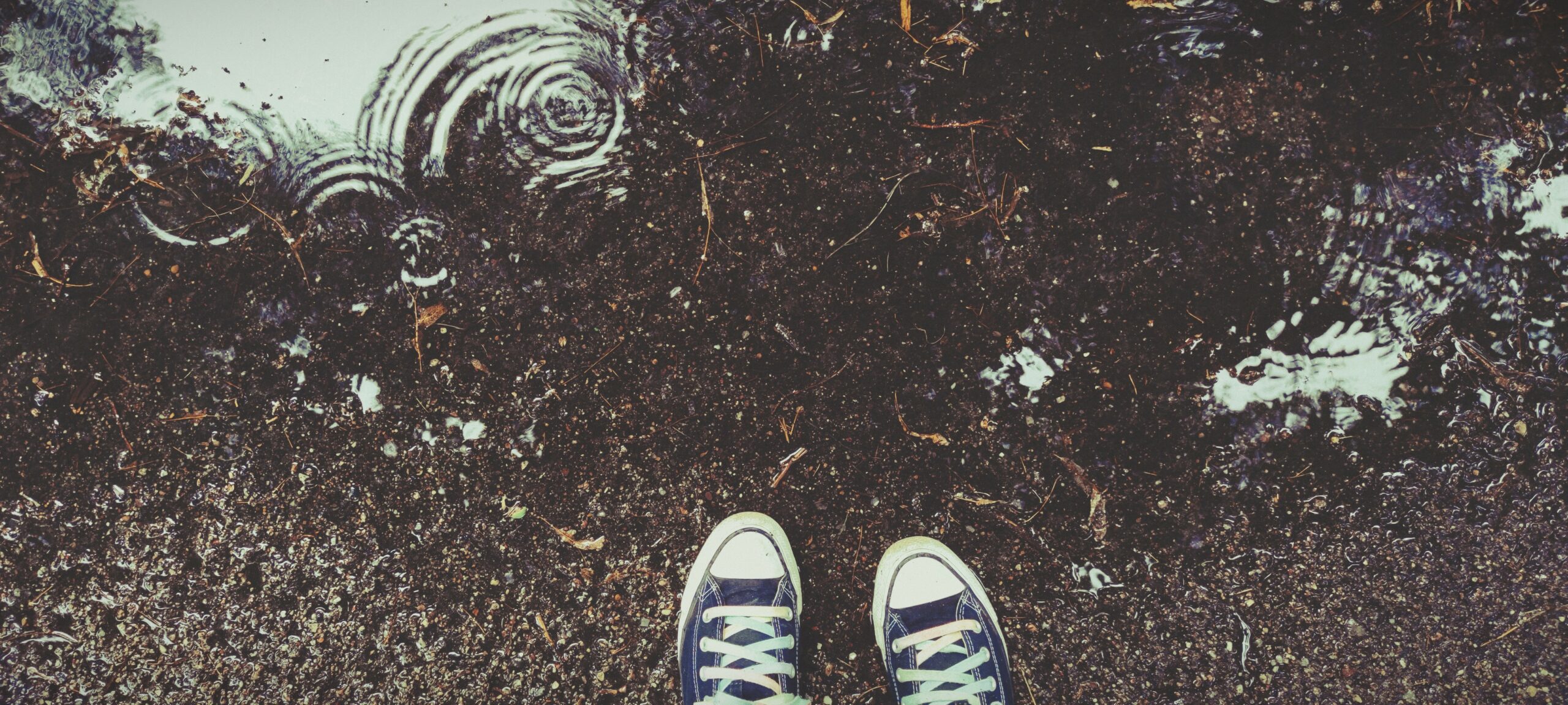 Blick von oben. Sneaker und Pfütze im Regen